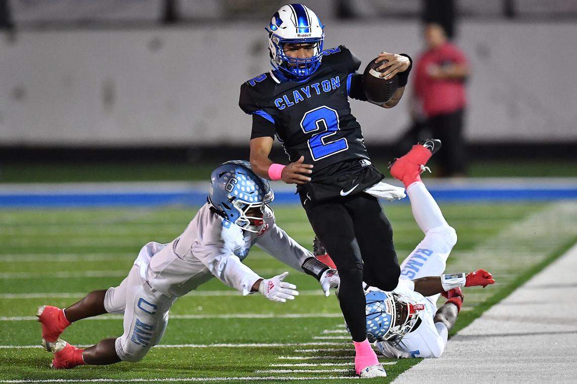 Clayton quarterback Aiden Smalls (2) runs on the sidelines against Cleveland's Kaleb Ferrell (0) and Porter Bennett (5) during the first half. The Cleveland Rams took on the Clayton Comets in a conference football game in Clayton, N.C. on October 31st in Clayton, N.C.