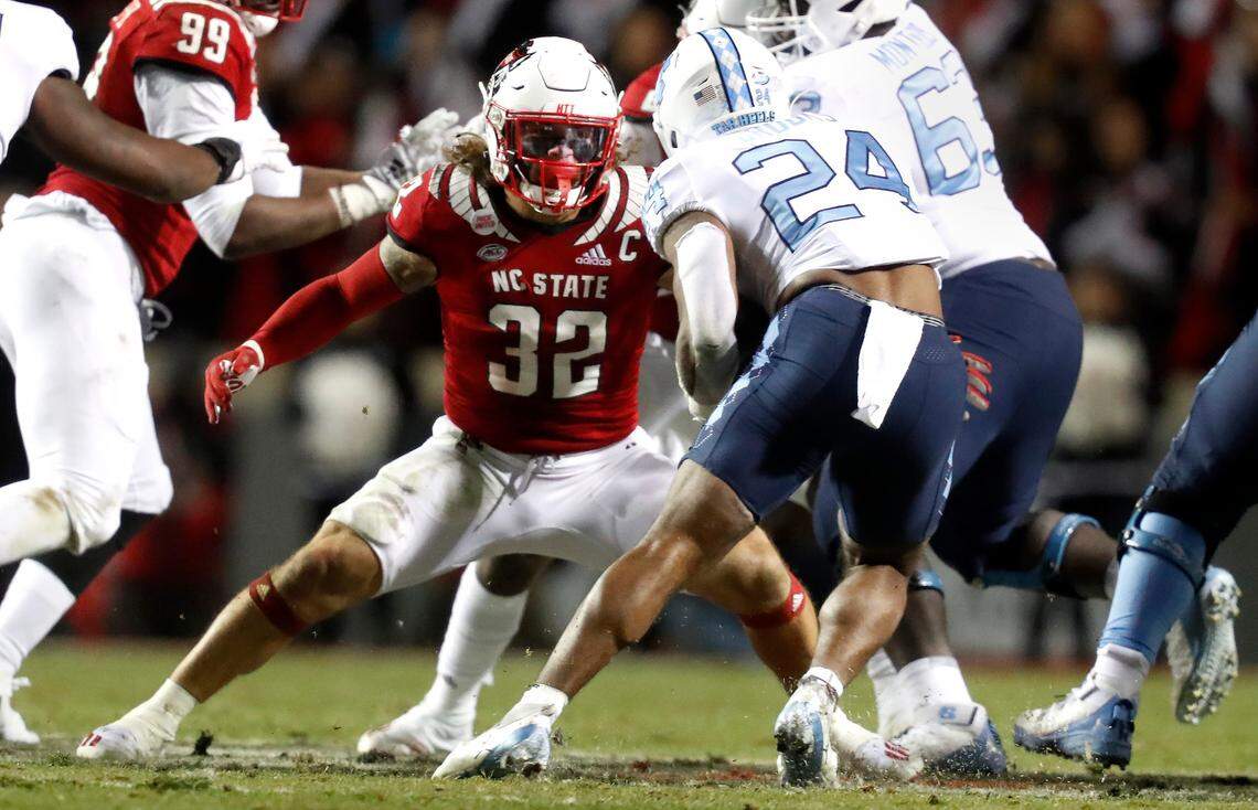 N.C. State linebacker Drake Thomas (32) looks to stop North Carolina running back British Brooks (24) during the Wolfpack’s game against the Tar Heels at Carter-Finley Stadium in Raleigh in November 2021.