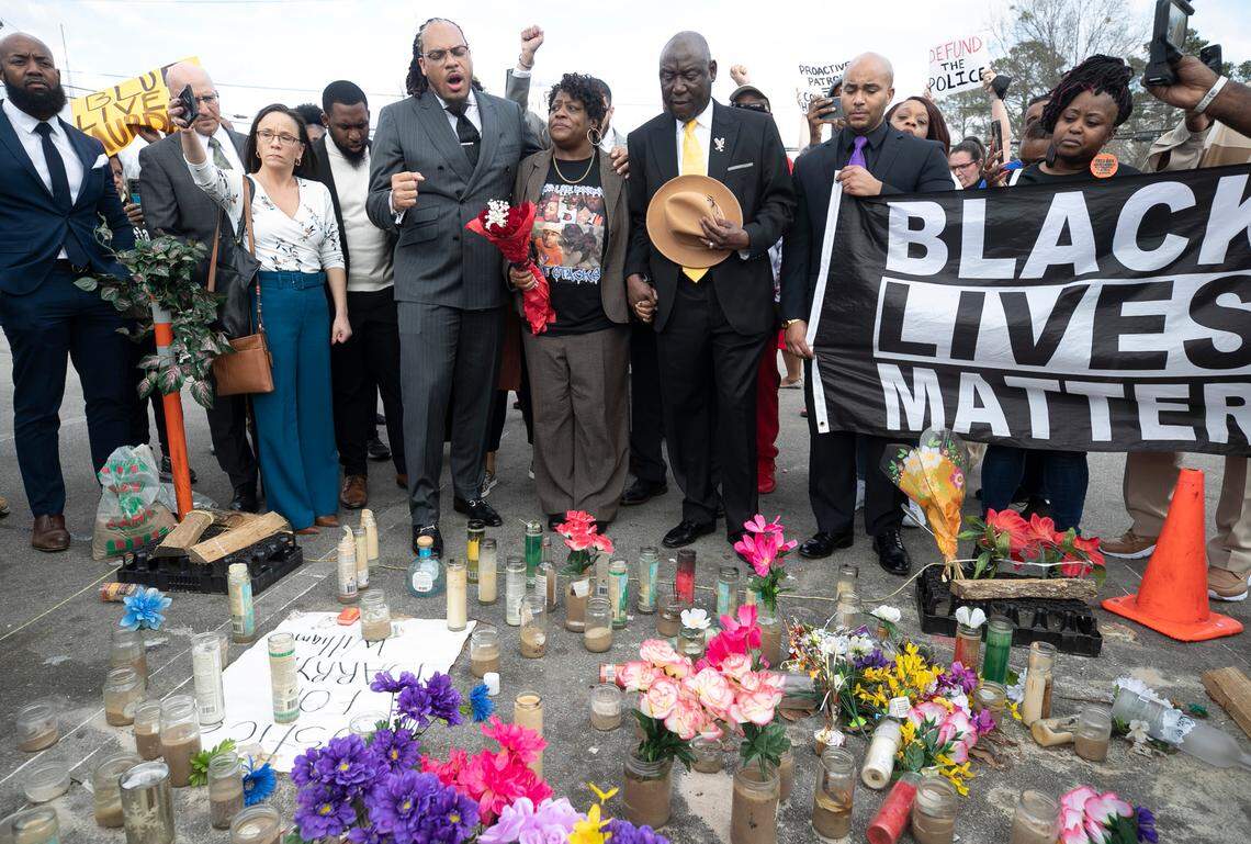Rev. Greg Drumwright says a prayer moments before Sonya Williams laid a bouquet of flowers on a memorial for her son Darryl Williams on Rock Quarry Road on Thursday, February 16, 2023 in Raleigh, N.C. Williams died after being tased by Raleigh police in January.