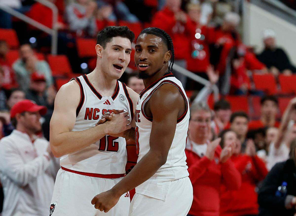 N.C. State’s Michael O’Connell and Marcus Hill celebrate in the closing seconds of the Wolfpack’s 84-74 overtime win over Florida State on Saturday, Dec. 7, 2024, at Lenovo Center in Raleigh, N.C.