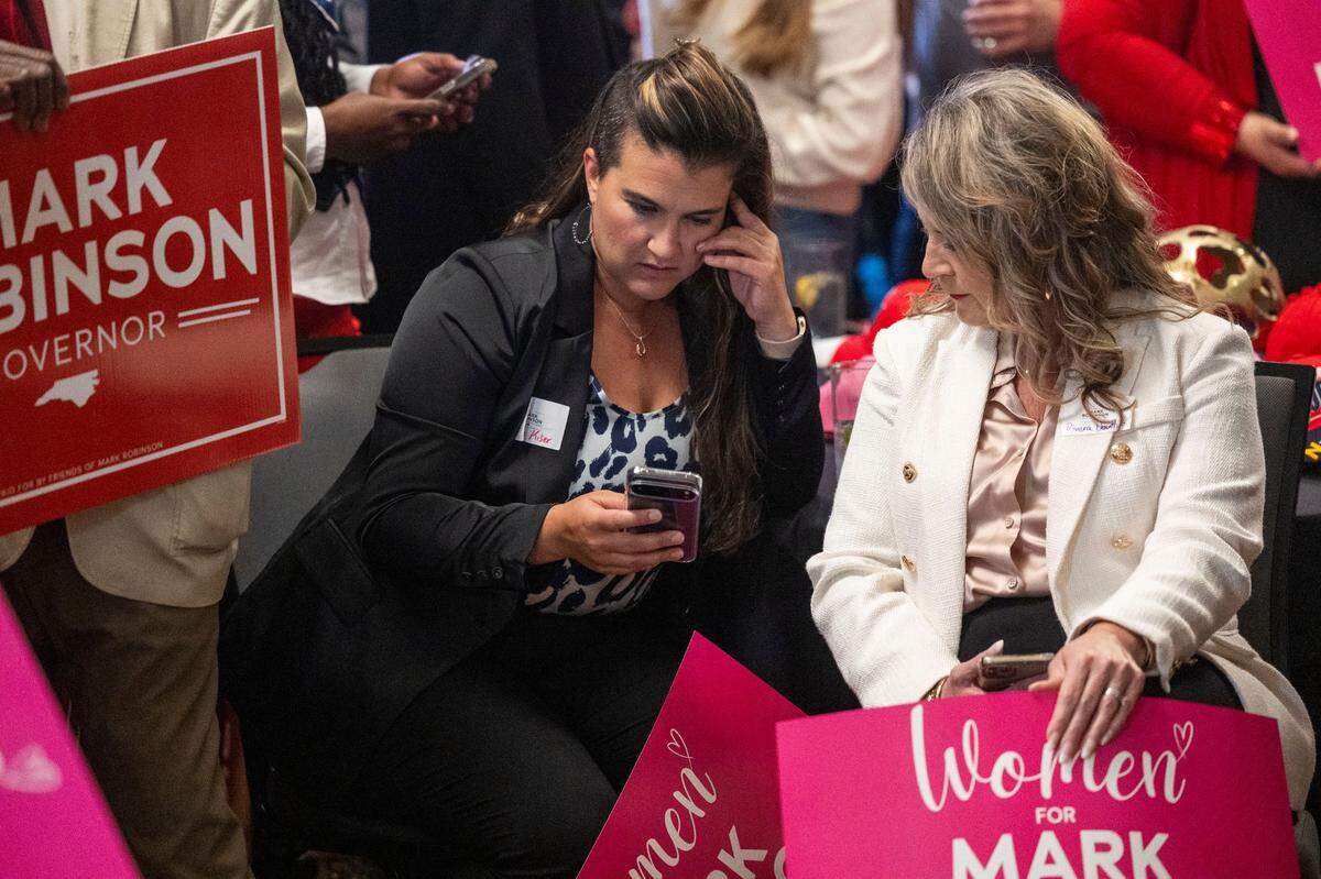 Supporters of Republican gubernatorial candidate Lt. Gov. Mark Robinson check poll results before Robinson made a concession speech during an election watch party at the City Club in Raleigh after loosing the North Carolina gubernatorial race to Democratic nominee Attorney General Josh Stein on Election Day, Tuesday, Nov. 5, 2024.