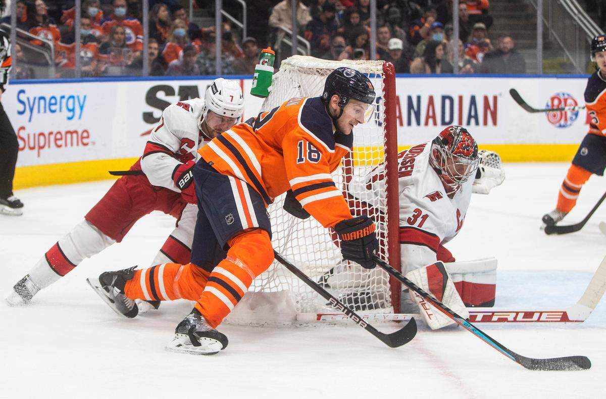 Carolina Hurricanes goalie Frederik Andersen (31) makes a save on Edmonton Oilers’ Zach Hyman (18) as Brendan Smith (7) defends during the second period of an NHL hockey game Saturday, Dec. 11, 2021, in Edmonton, Alberta. (Jason Franson/The Canadian Press via AP)