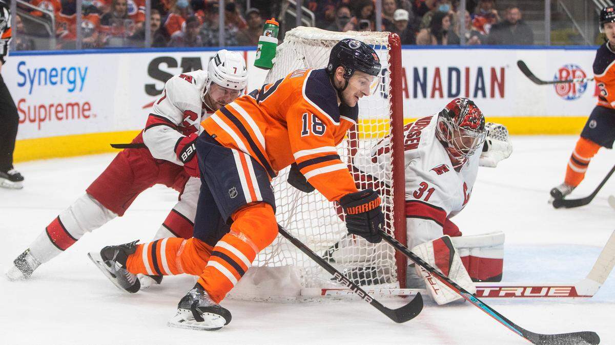 Carolina Hurricanes goalie Frederik Andersen (31) makes a save on Edmonton Oilers’ Zach Hyman (18) as Brendan Smith (7) defends during the second period of an NHL hockey game Saturday, Dec. 11, 2021, in Edmonton, Alberta. (Jason Franson/The Canadian Press via AP)