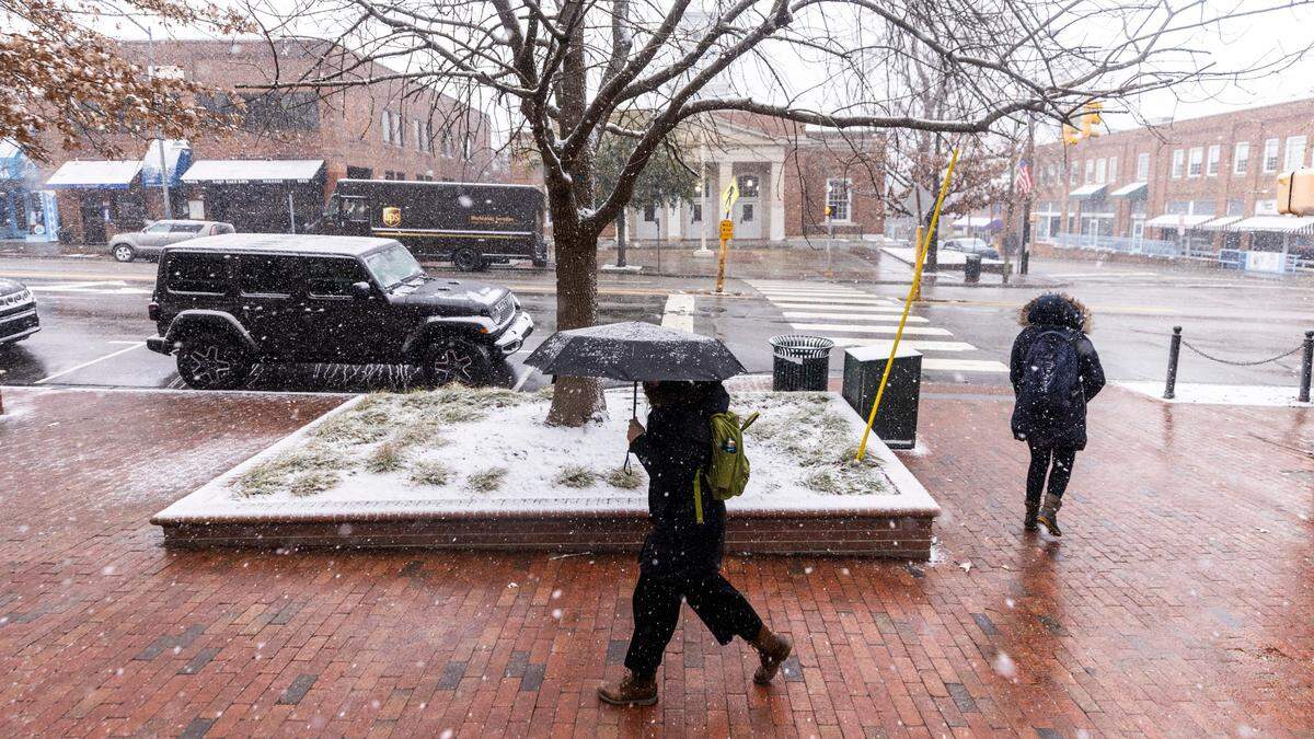 Pedestrians brave the freezing temperature as snow begins to fall at UNC-Chapel Hill on Wednesday, Feb. 19, 2024.