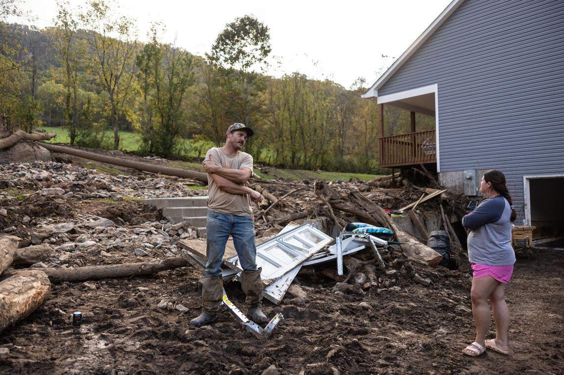 Dakota Ball, left and his wife, Kelli, stand in the area next to their home where a landslide came through in Barnardsville, N.C. on Wednesday, October 2, 2024.