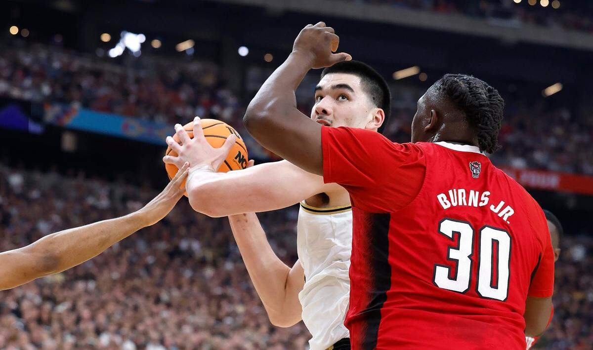 N.C. State’s DJ Burns Jr. (30) and Casey Morsell (14), left, defend Purdue’s Zach Edey (15) during the first half of N.C. State’s game against Purdue in the NCAA Tournament national semfinals at State Farm Stadium in Glendale, Ariz., Saturday, April 6, 2024.