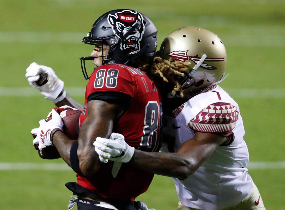 N.C. State wide receiver Devin Carter (88) makes the catch while defended by Florida State defensive back Jarrian Jones (7) during the first half of N.C. State’s game against Florida State at Carter-Finley Stadium in Raleigh, N.C., Saturday, Nov. 14, 2020.