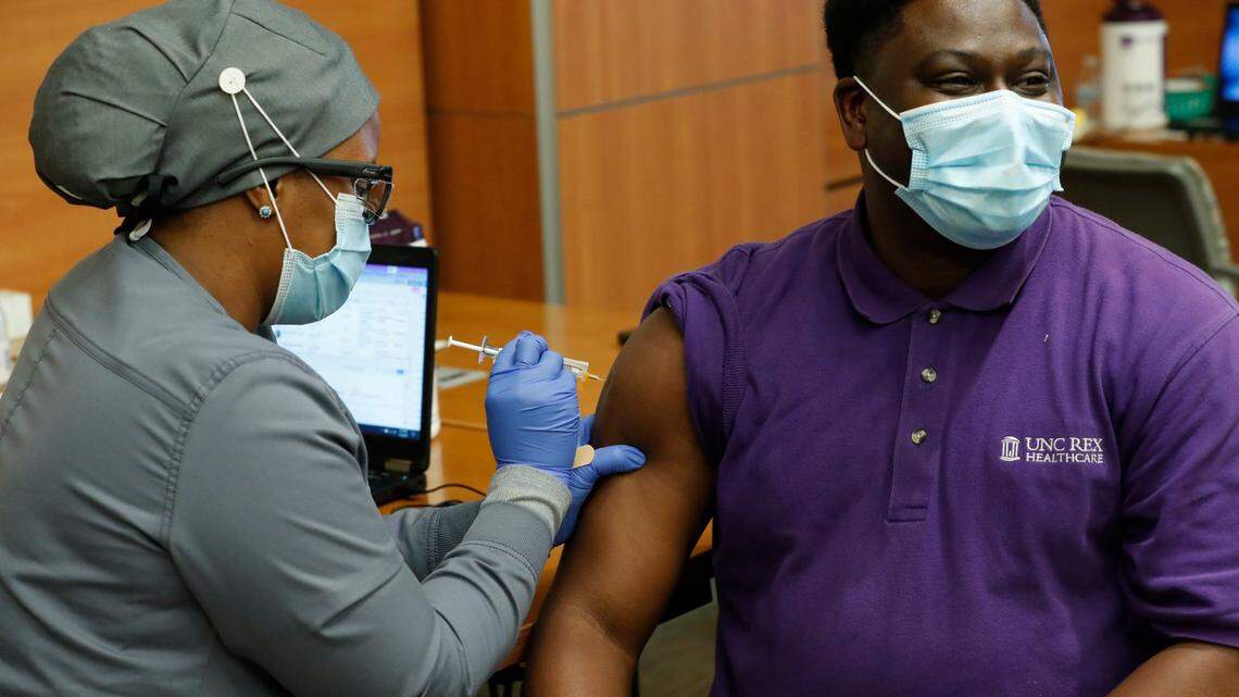 Gyasi Patterson, Pastoral Care Services Manager at UNC REX Healthcare, gets his COVID-19 vaccine shot from Krisse Meeks, medical assistant, during a vaccination clinic for employees on Jan. 7.