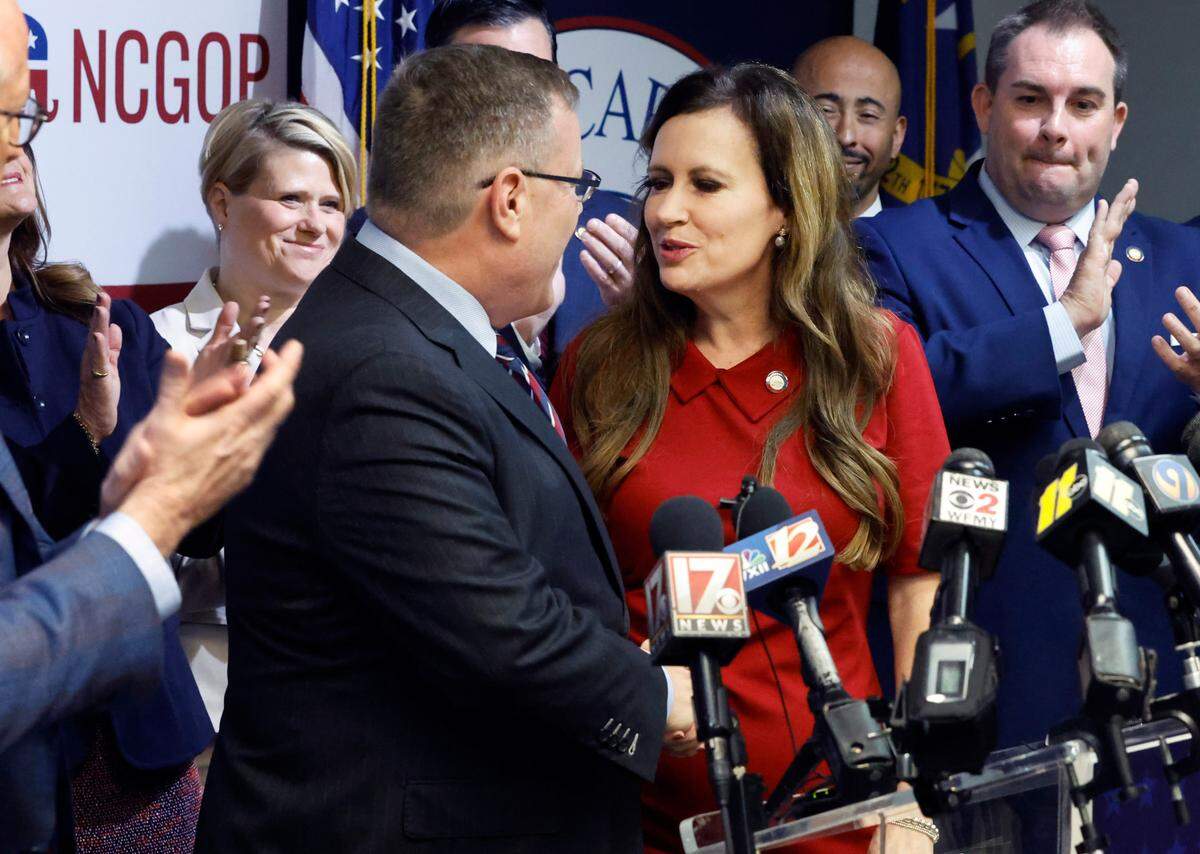 N.C. House Speaker Tim Moore, left, congratulates N.C. State Rep. Tricia Cotham as she heads up to the podium to speak during a press conference at the N.C. GOP headquarters in Raleigh, N.C., Wednesday, April 5, 2023. The press conference was to announce Rep. Cotham is switching parties to become a member of the House Republican caucus.