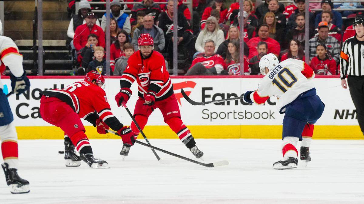 Florida Panthers left wing A.J. Greer (10) scores a goal on his shot past Carolina Hurricanes defenseman Sean Walker (26) and defenseman Shayne Gostisbehere (4) during the third period at Lenovo Center.