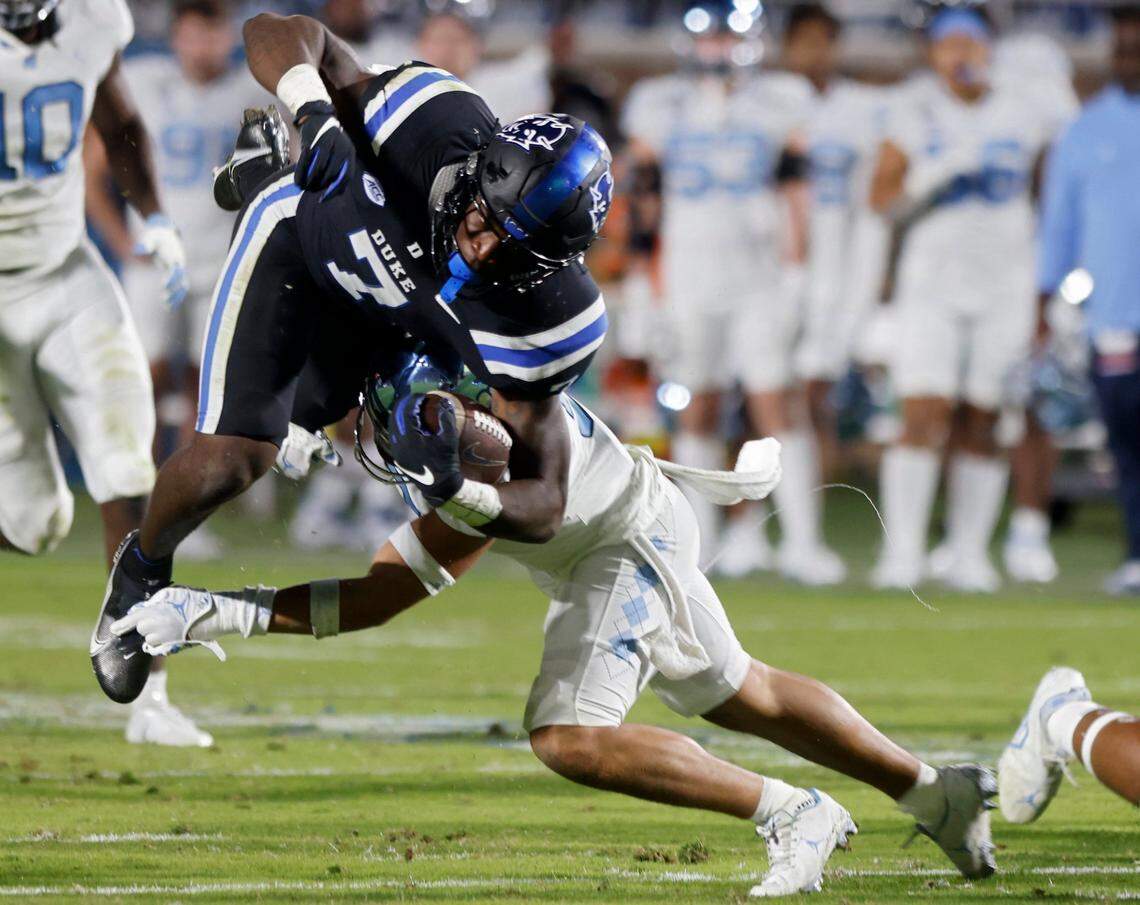Duke Blue Devils running back Jordan Waters (7) is tackled by North Carolina Tar Heels defensive back Cam’Ron Kelly (9) during the first half of Saturday’s game at Wallace Wade Stadium in Durham, N.C.