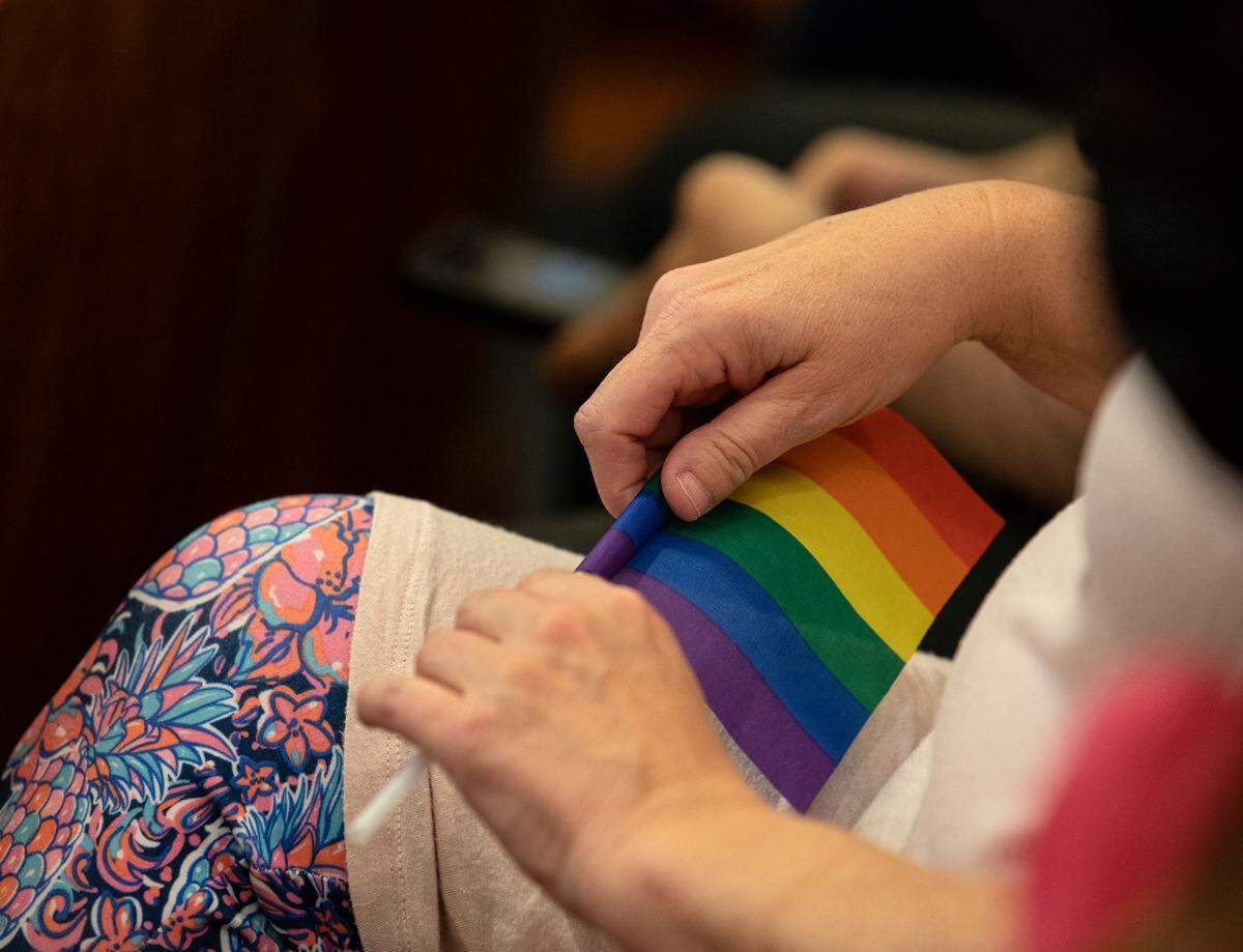 A person holds a rainbow flag during a Holly Springs Town Council meeting on Tuesday, June 7, 2022 in Holly Springs, N.C. Requests for the town to issue a proclamation for Pride Month have been unsuccessful.