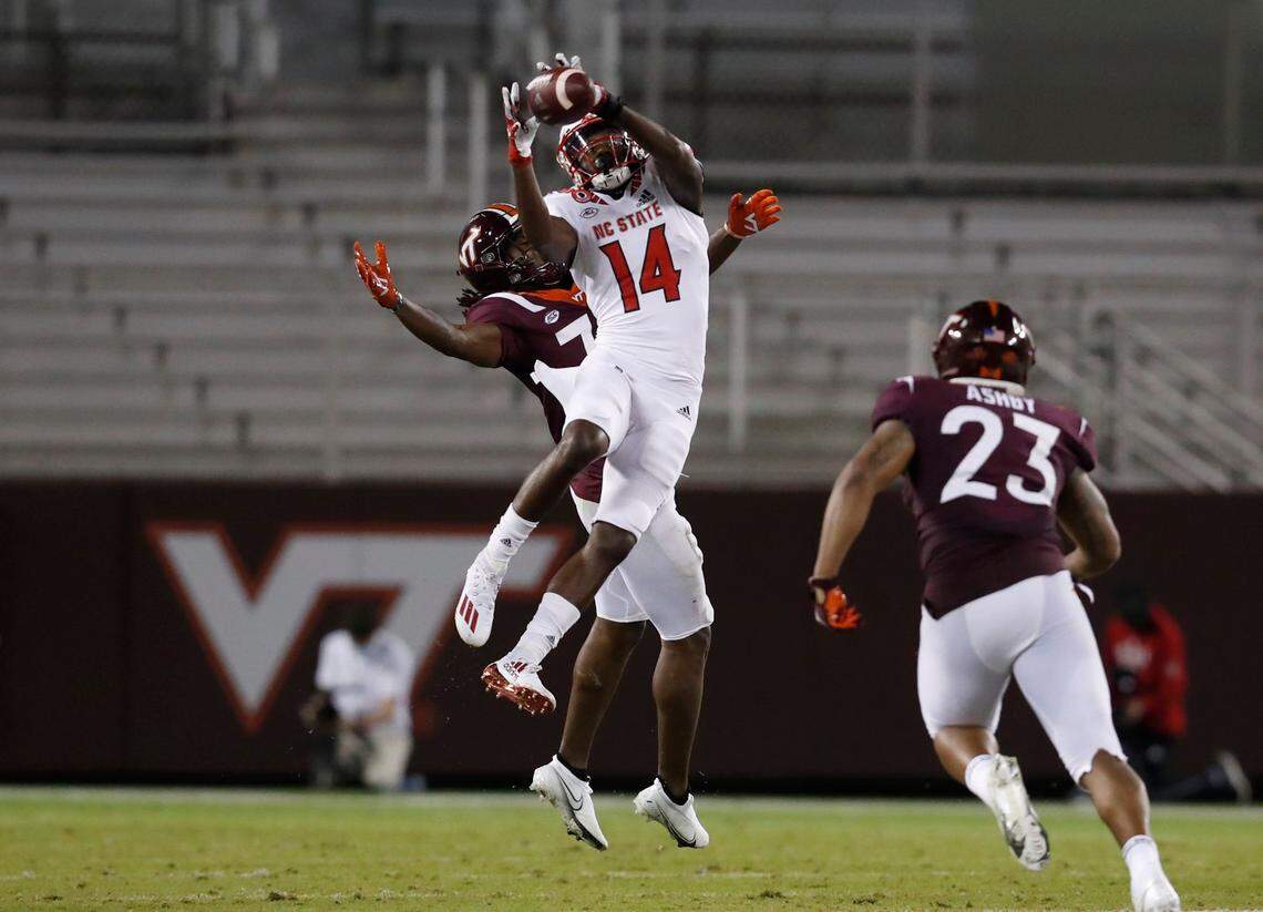 N.C. State wide receiver Porter Rooks (14) makes the reception as Virginia Tech defensive back Keonta Jenkins (33) defends during the first half of N.C. State’s game against Virginia Tech at Lane Stadium in Blacksburg, VA Saturday, Sept. 26, 2020.