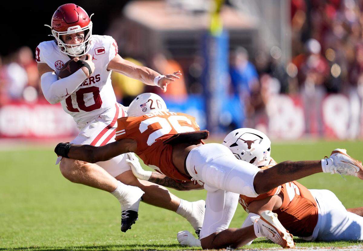 Oklahoma Sooners quarterback John Mateer (10) tries to get by Texas Longhorns linebacker Ty'Anthony Smith (26) in the first half of the Red River Rivalry college football game between the University of Oklahoma Sooners and the Texas Longhorn at the Cotton Bowl Stadium in Dallas, Texas, Saturday, Oct. 11, 2025.