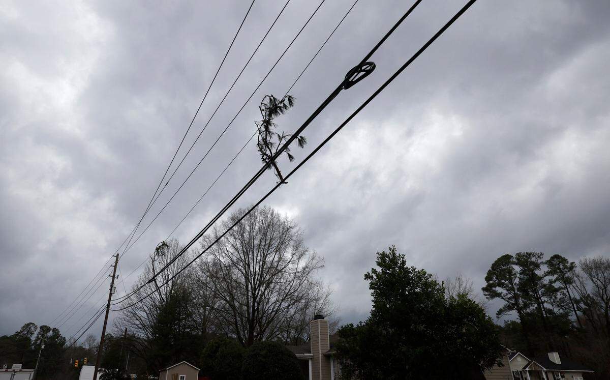 A branch is stuck is captured on power lines on Woodland Road in Garner, N.C., Sunday, Dec. 10, 2023. A powerful storm roared through the area, knocking down trees and cutting off power.