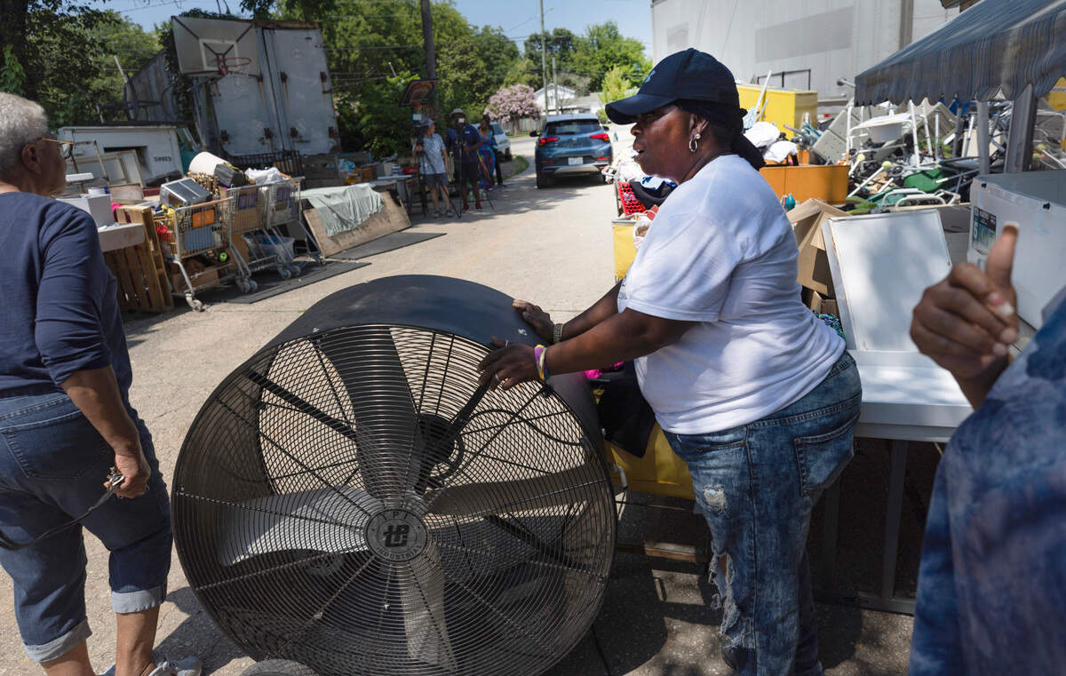 Sylvia Wiggins helps distribute fans and water bottles at Helping Hand Mission in Raleigh during a heat wave on Friday, June 27, 2025. ‘It’s like Christmas,’ Wiggins said, ‘Being able to give like this.’