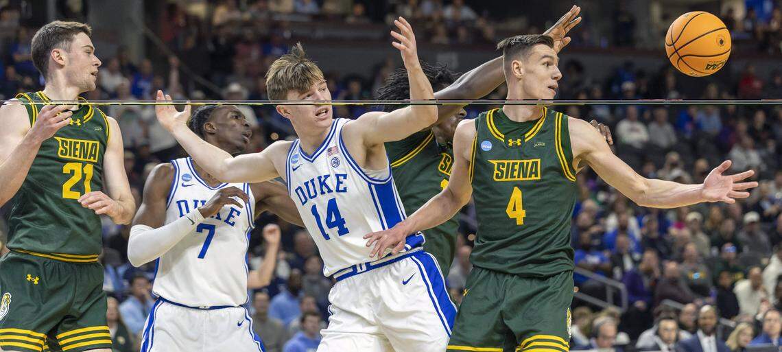 Duke guard Nikolas Khamenia (14) looses control of the ball under defensive pressure from Siena in the first half on Thursday, March 18, 2026, during the first round of the NCAA Tournament at Bon Secours Arena in Greenville, S.C.