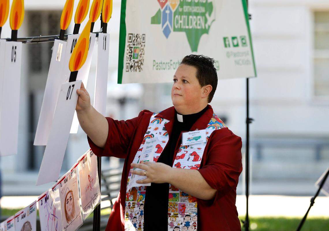 The Rev. Suzanne Miller, Executive Director of Pastors For North Carolina Children, places a paper candle on a display during a prayer vigil led by Pastors For North Carolina Children in Raleigh, N.C. Wednesday, August 31, 2022, urging the N.C. Supreme Court to order the state to fund the Leandro plan. There are 28 candles on the display, one for each year the schools haven’t been funded since the Leandro case was filed.