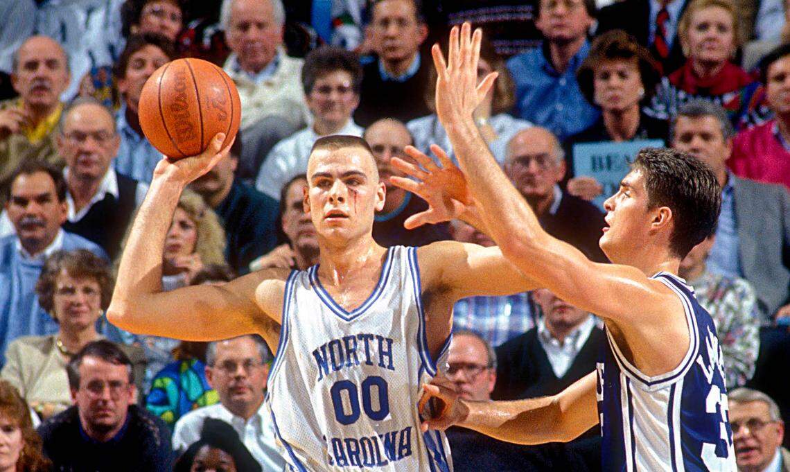 North Carolina Tar Heels center Eric Montross (00) looks to pass as Duke Blue Devils center Christian Laettner (32) defends in the Tar Heels 75-73 victory against the Blue Devils at the Dean E. Smith Center. Montross is playing with a cut below his left eye.