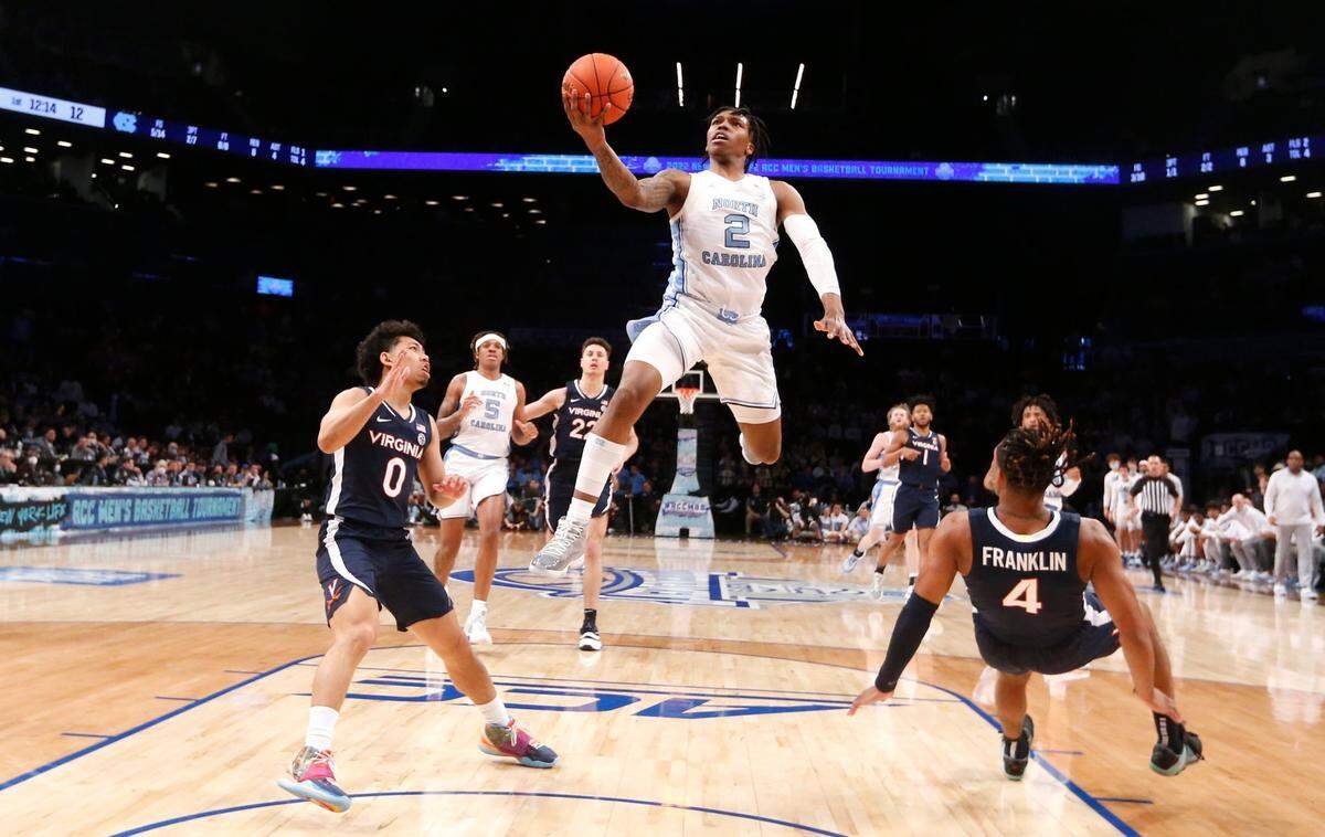 North Carolina’s Caleb Love (2) heads to the basket after being fouled by Virginia’s Armaan Franklin (4) during UNCs 63-43 victory over Virginia in the quarterfinals of the ACC mens basketball tournament at the Barclays Center in Brooklyn, N.Y., Thursday, March 10, 2022. Virginia’s Kihei Clark (0) is to the left.