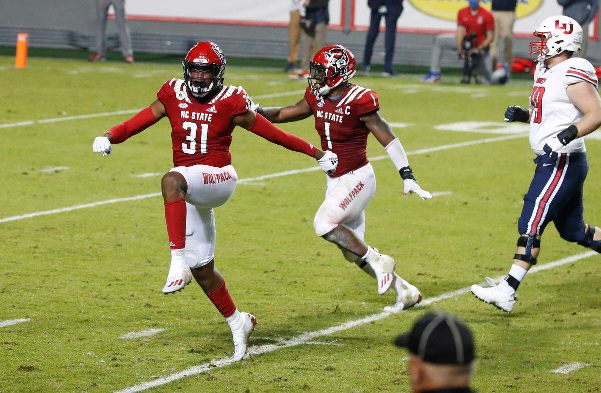 N.C. State’s Vi Jones (31) and Isaiah Moore (1) celebrate after Jones blocked the field goal attempt by Liberty’s Alex Barbir (95) during the second half of N.C. State’s 15-14 victory over Liberty at Carter-Finley Stadium in Raleigh, N.C., Saturday, Nov. 21, 2020.