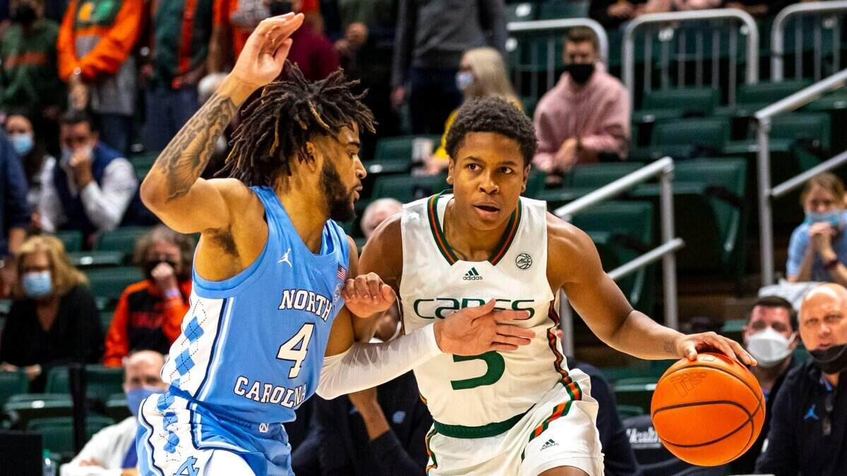 University of Miami point guard Charlie Moore (3) penetrates while defended by University of North Carolina guard RJ Davis (4) during the first half of an NCAA basketball game at the Watsco Center in Coral Gables, Florida, on Tuesday, January 18, 2022.