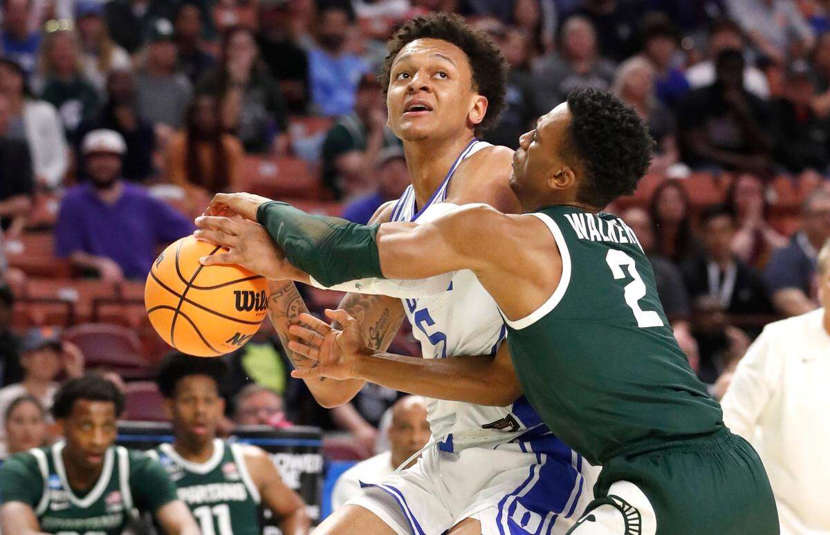 Michigan State’s Tyson Walker (2) knocks the ball from Dukes Paolo Banchero (5) during the first half of Dukes game against Michigan State in the second round of the NCAA Tournament at Bon Secours Wellness Arena in Greenville, S.C., Sunday, March 20, 2022.
