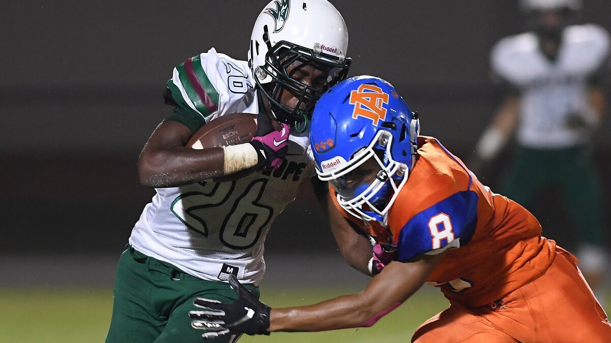 Joshua Hullum (26) of Green Hope moves the ball against Omari Cotton (8) of Athens Drive. The Green Hope Falcons visited the Athens Drive Jaguars in a high school football game on October 15, 2018. Green Hope won 33-9.