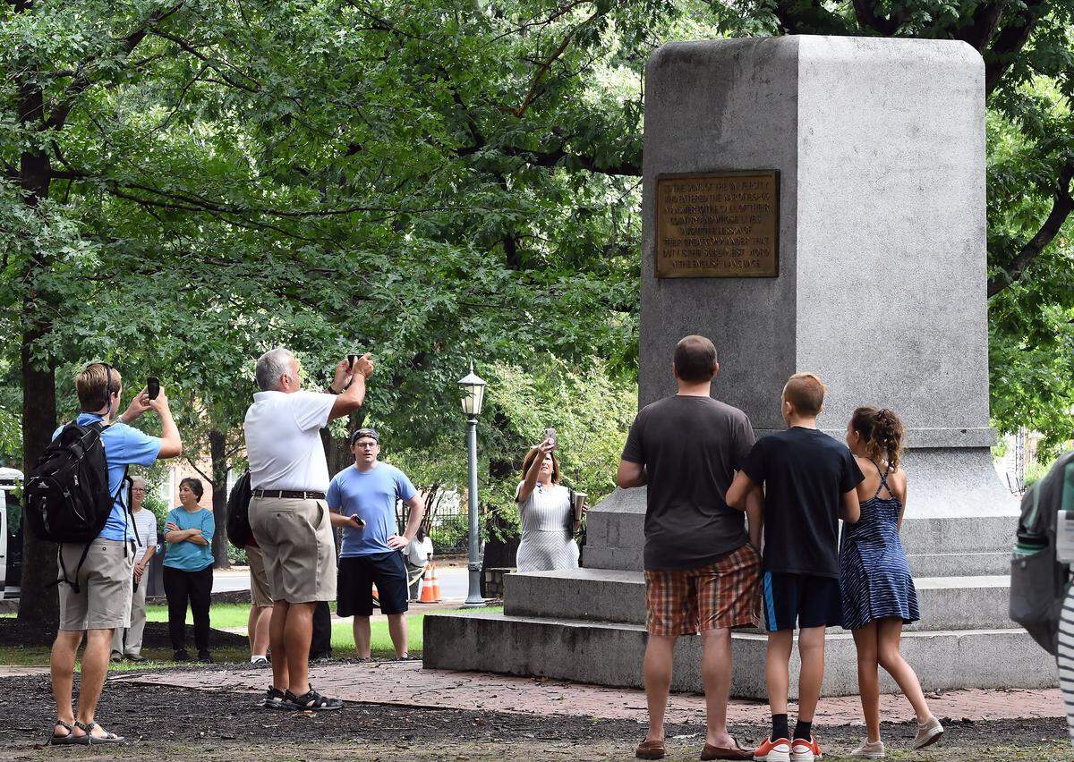 A group of people celebrate and take photos at the base of the pedestal where of the Silent Sam statue stood Tuesday, Aug. 21, 2018, on the campus of UNC in Chapel Hill, N.C.