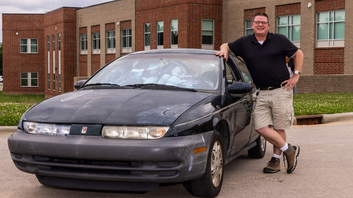 Chapel Hill High history teacher Bill Melega with his 1996 Saturn.