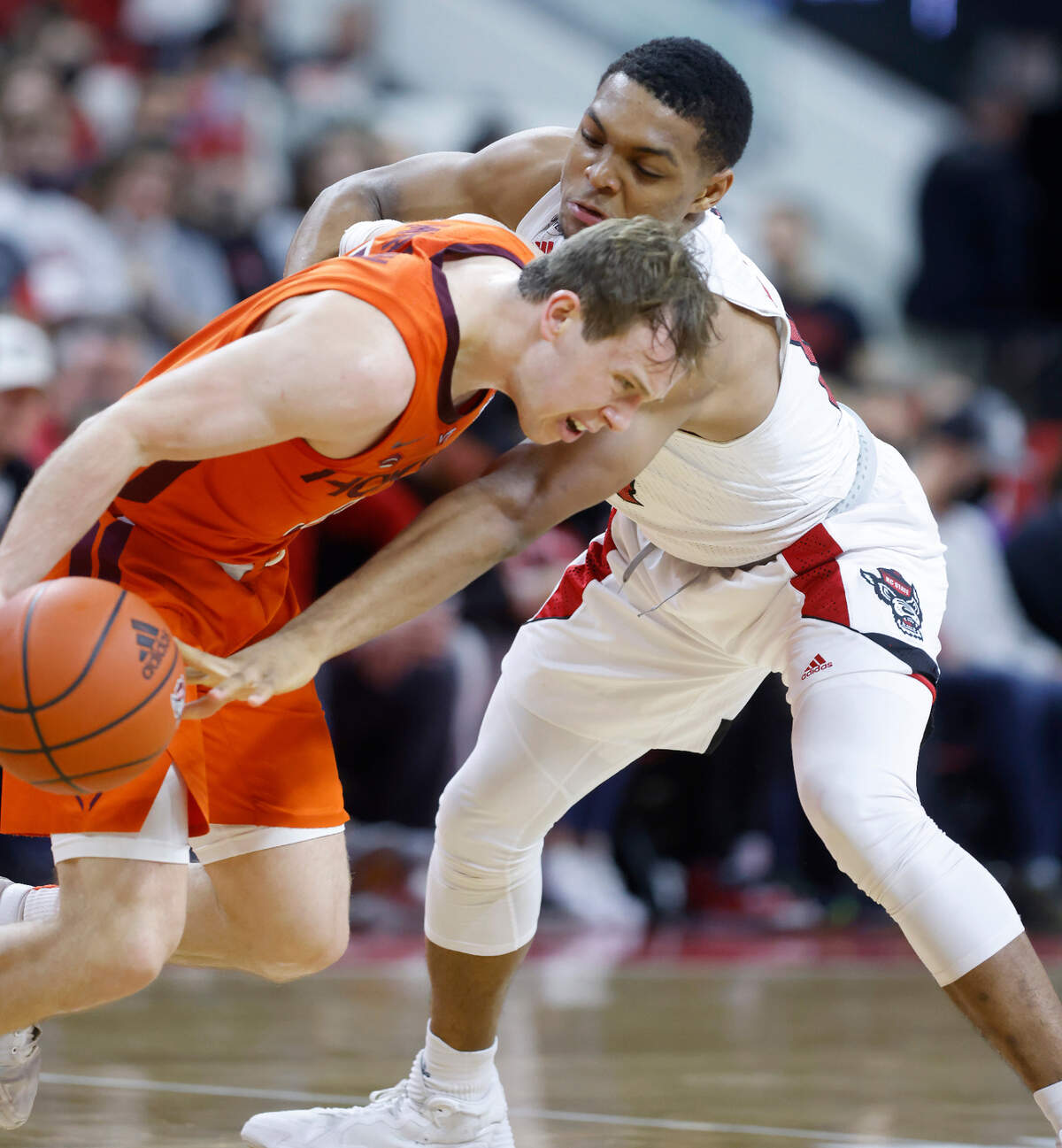 N.C. State’s Casey Morsell (14) was called for a foul while knocking the ball from Virginia Tech’s Storm Murphy (5) during the second half of Virginia Tech’s 62-59 victory over N.C. State at PNC Arena in Raleigh, N.C., Wednesday, Jan. 19, 2022.