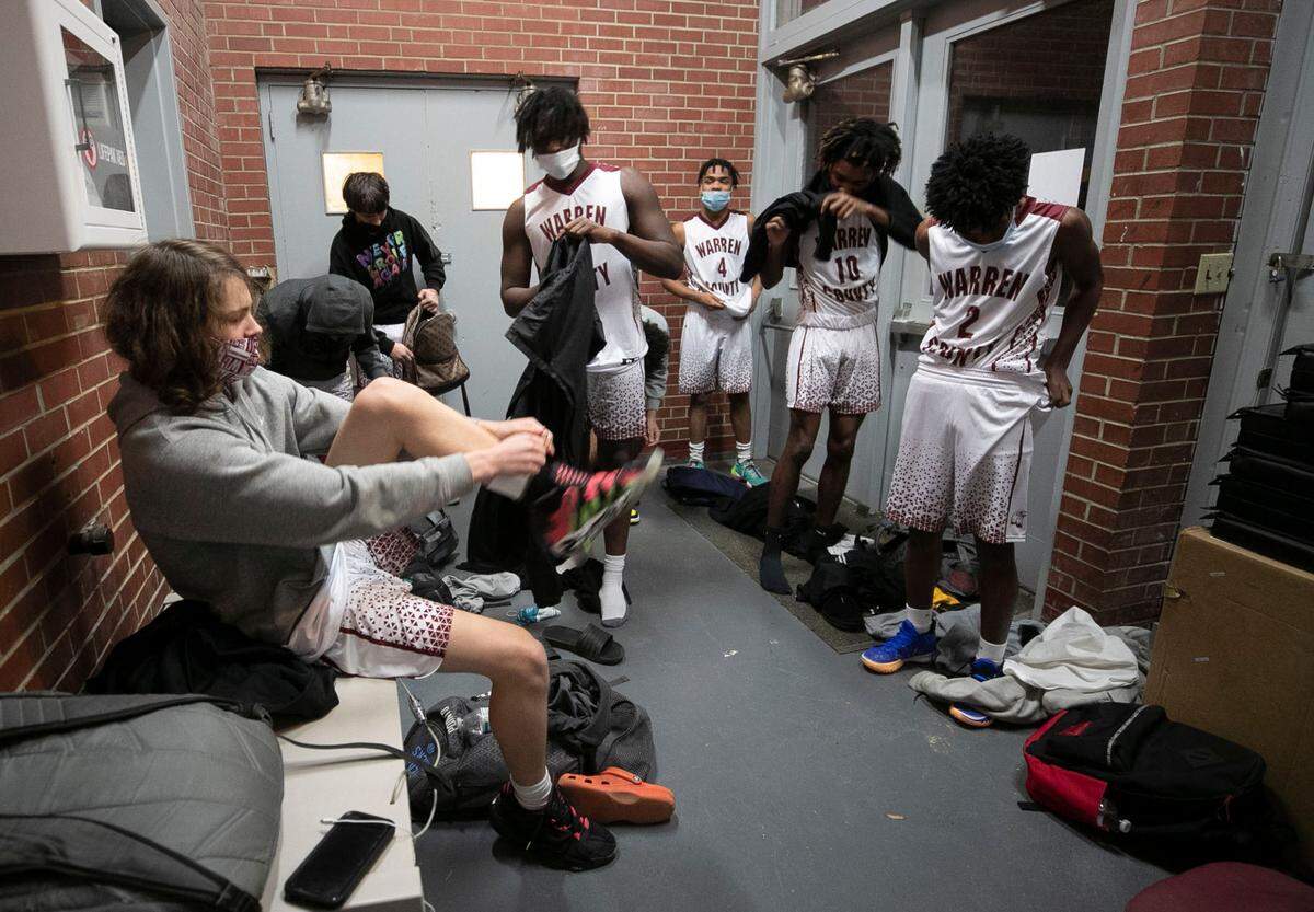 Warren County High School players change into their game uniforms in a lobby at the John Graham Gym on Tuesday, February, 2, 2021 in Warrenton, N.C. The team is using the Warren County recreation center gym with no locker-rooms for their home games while their school gym is renovated.