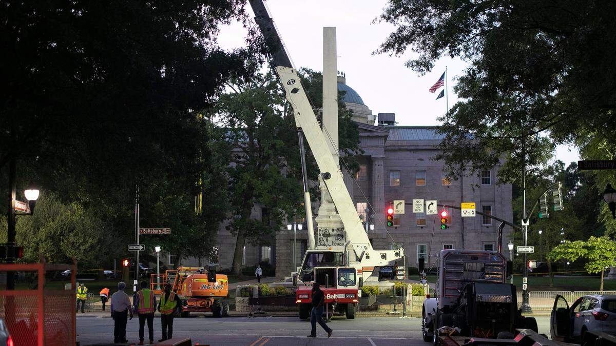 After four hours of working during the early morning hours of Tuesday, June 23, 2020 to remove the Confederate monument on the west side of the North Carolina State Capital in Raleigh, N.C., crews take down their equipment to reassess and plan another strategy for its removal.