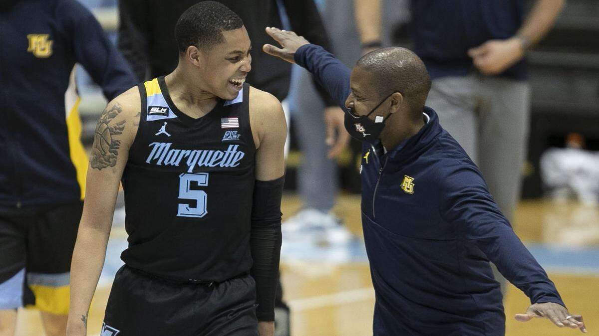 Then-Marquette associate head coach Justin Gainey celebrates with Greg Elliott after defeating North Carolina on Wednesday, Feb. 24, 2021, at the Smith Center in Chapel Hill, North Carolina.