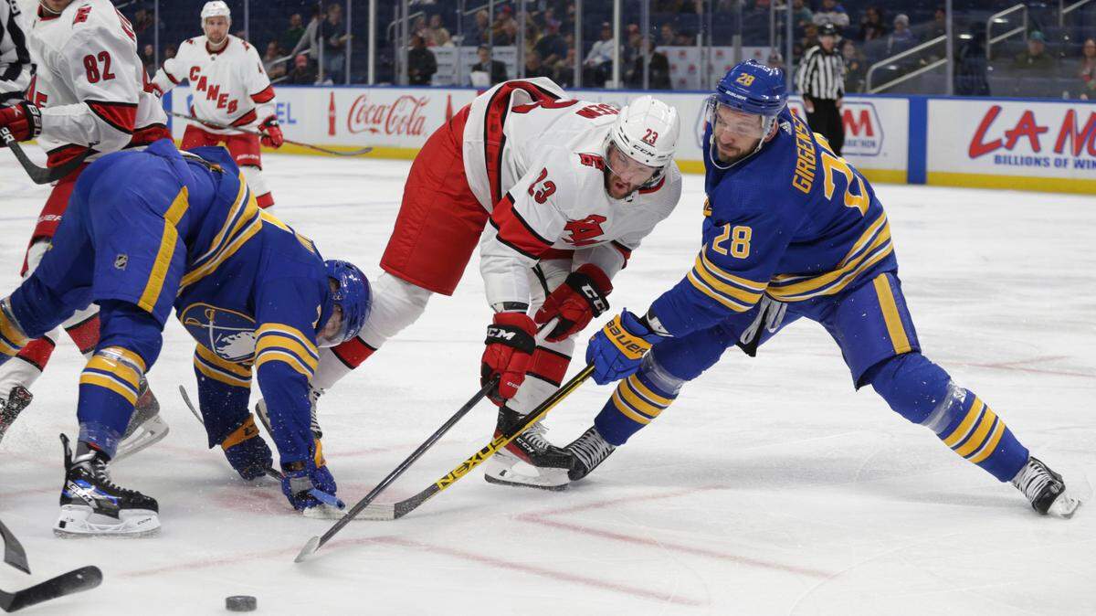 Carolina Hurricanes forward Stefan Noesen (23) and Buffalo Sabres left wing Zemgus Girgensons (28) battle for the puck during the first period of a preseason NHL hockey game Tuesday, Oct. 4, 2022, in Buffalo, N.Y. (AP Photo/Joshua Bessex)