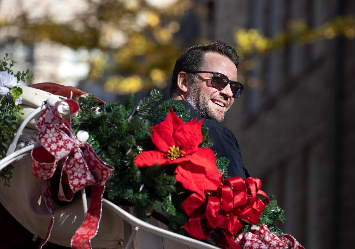 Cam Ward, a former member of the Carolina Hurricanes, smiles as he rides in a horse-drawn carriage while serving as the Grand Marshal of the Raleigh Christmas Parade on Saturday, Nov. 18, 2023.