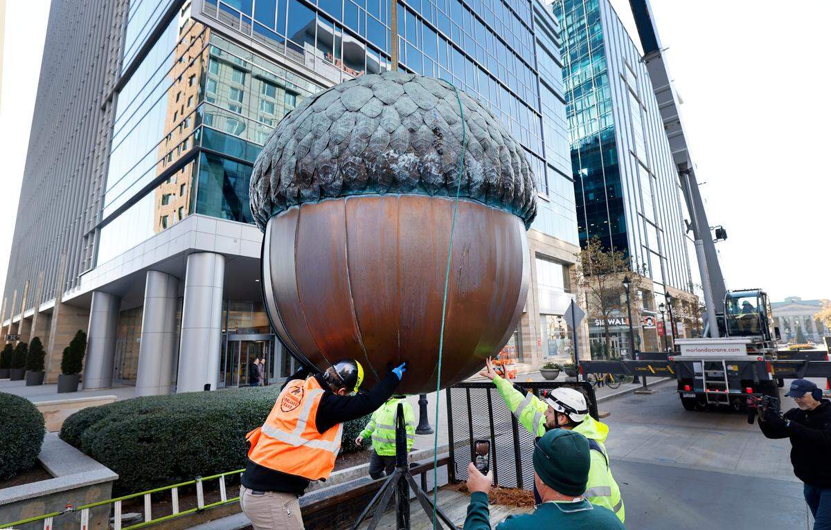 Crews from Morlando Crane and the City of Raleigh move the 10-foot tall, 1,250-pound acorn sculpture from its home in City Plaza in downtown Raleigh to a trailer Thursday morning, Dec. 5, 2024. The acorn will be temporarily moved to artist David Benson’s studio to be polished before it returns downtown to be dropped on New Year’s Eve as part of First Night Raleigh.