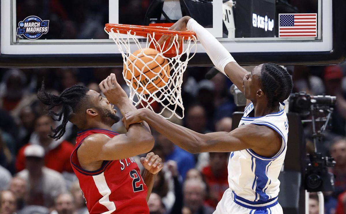 Duke’s Dame Sarr (7) slams in two as St. John's Zuby Ejiofor (24) defends during the first half of Duke’s game against St. John’s in the Sweet 16 of the NCAA Men’s Basketball East Regional at Capital One Arena in Washington, D.C., Friday, March 27, 2026.