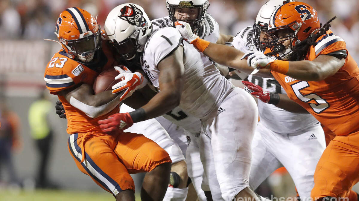 N.C. State defensive end James Smith-Williams (1) tackles Syracuse running back Abdul Adams (23) during the first half of N.C. State’s game against Syracuse at Carter-Finley Stadium in Raleigh, N.C., Thursday, Oct. 10, 2019.