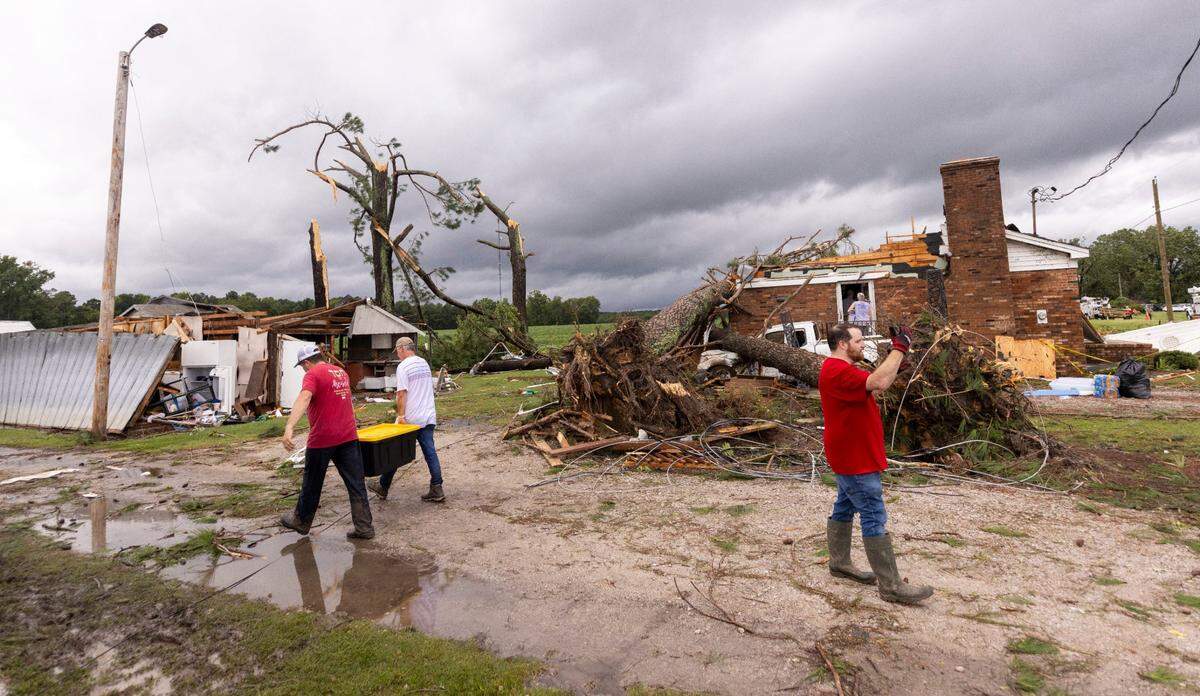 Volunteers help clean up a home that was damaged by a tornado that spun out of Tropical Storm Debby early Thursday Aug. 8, 2024 in Wilson County. Multiple homes and a middle school were heavily damaged by the tornado.