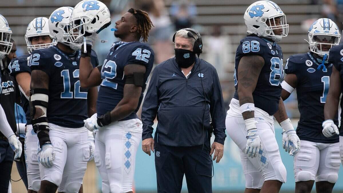 North Carolina coach Mack Brown huddles with the defensive unit during a time-out in the second quarter on Saturday, October 10, 2020 at Kenan Stadium in Chapel Hill, N.C.