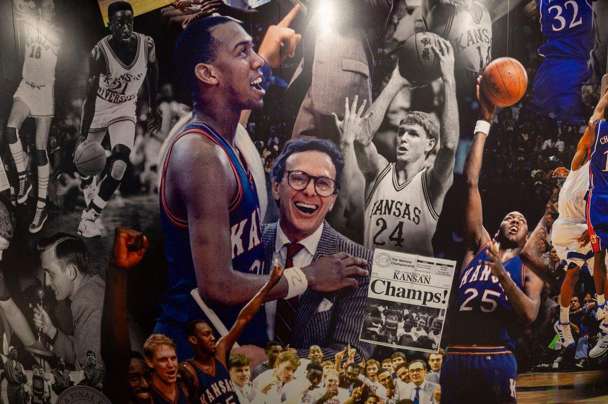 Kansas coach Larry Brown, who played at North Carolina, embraces Danny Manning, after winning the 1988 National Championship. They are featured in a mural of images documenting the history of Kansas basketball at Allen Fieldhouse on Thursday, November 7, 2024 in Lawrence, Kansas.
