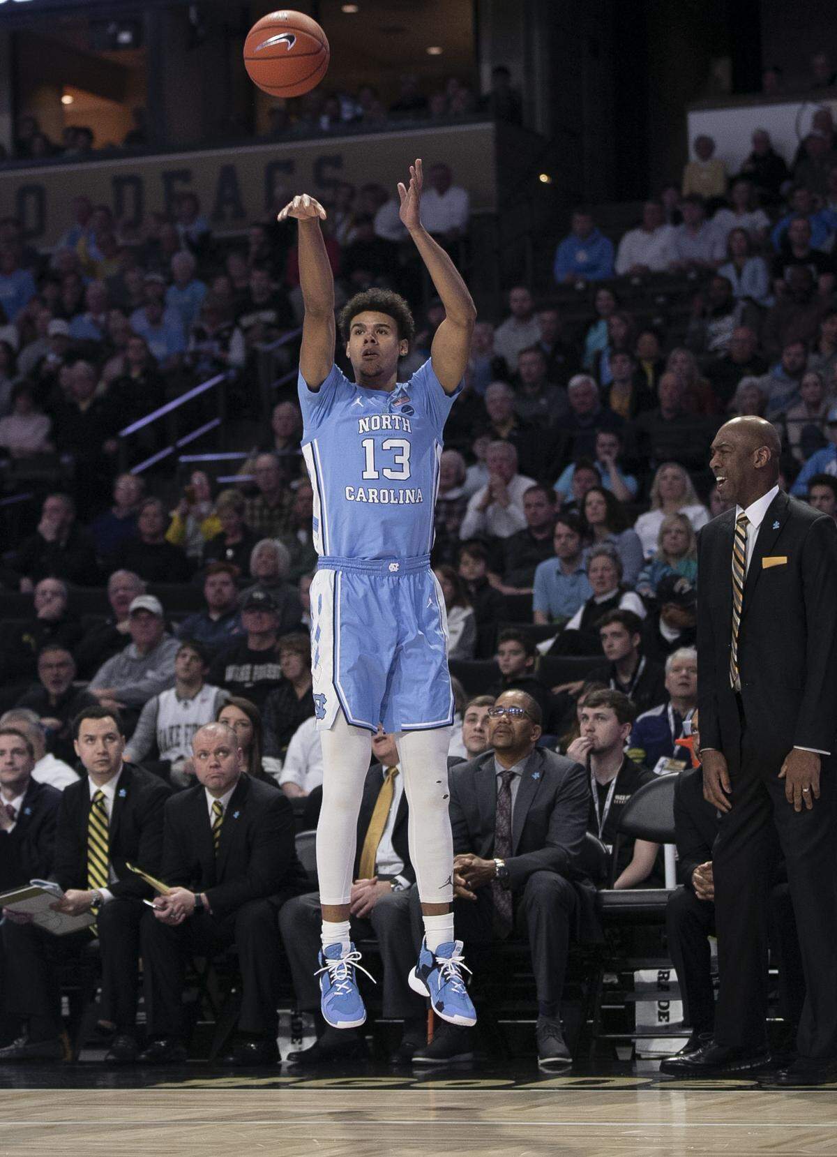 North Carolina’s Cameron Johnson (13) launches a three-point shot in front of Wake Forest coach Danny Manning during the first half on Saturday, February 16, 2019 at Lawrence Joel Coliseum in Winston-Salem, N.C. Johnson lead all scores with 27 points in the Tar Heels’ 95-57 victory.