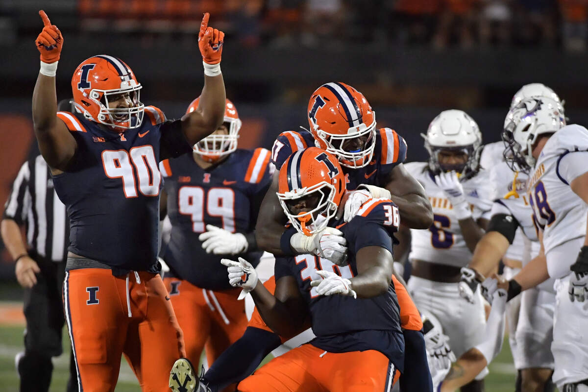 Aug 29, 2025; Champaign, Illinois, USA;  Illinois Fighting Illini linebacker Gabe Jacas (17) jumps on teammate Illinois Fighting Illini defensive lineman Eli Coenen (96) after a sack on Western Illinois Leathernecks quarterback Chris Irvin (5) during the first half at Memorial Stadium. Mandatory Credit: Ron Johnson-Imagn Images