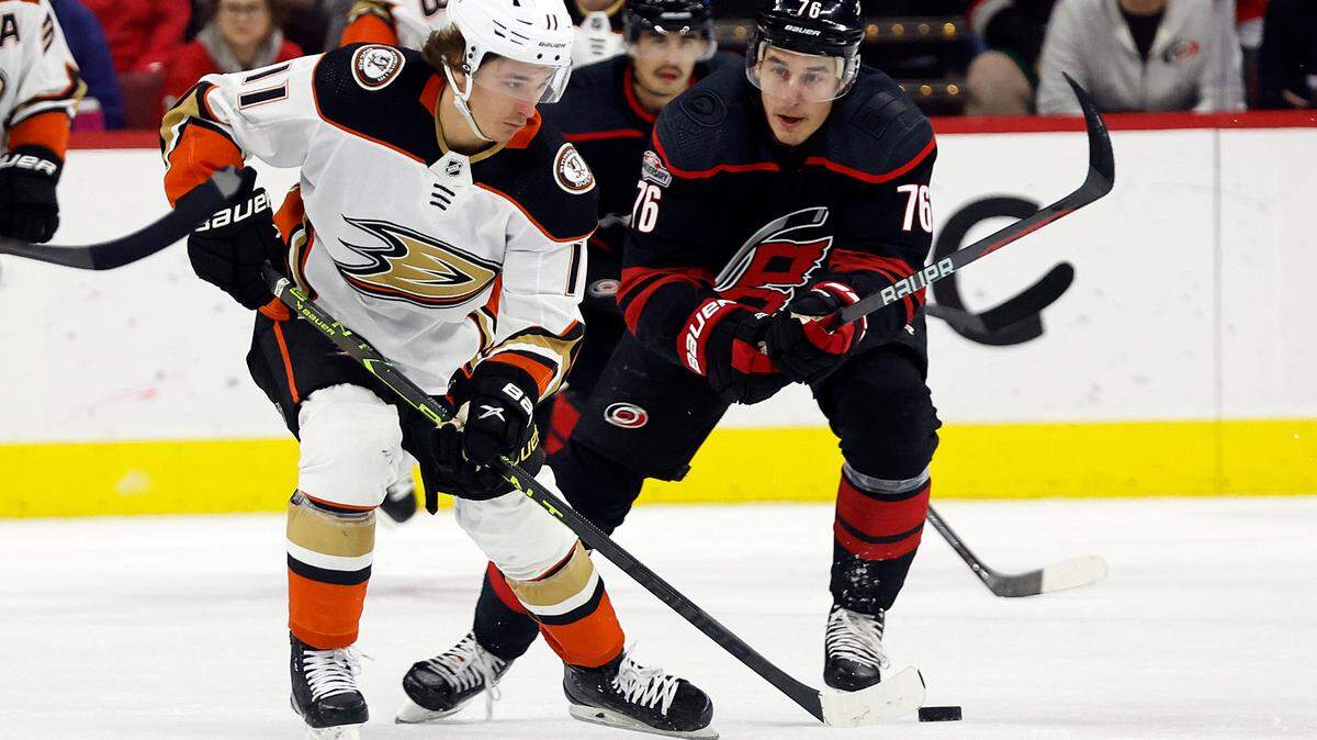 Anaheim Ducks’ Trevor Zegras (11) controls the puck in front of Carolina Hurricanes’ Brady Skjei (76) during the first period of an NHL hockey game in Raleigh, N.C., Saturday, Feb. 25, 2023. (AP Photo/Karl B DeBlaker)