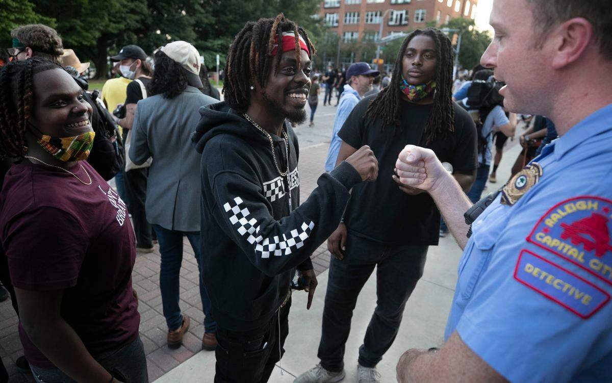 Raleigh Police Detective B.H. Winston, a veteran of 16 years, fist bumps Albert Fervily after having a conversation with Keesh Ormond, left and Dante Robinson following a rally at the Raleigh Municipal Building on Tuesday, June 2, 2020 in Raleigh, N.C. The photo took second place for general news photography among the state’s largest newspapers in the North Carolina Press Association’s annual awards.