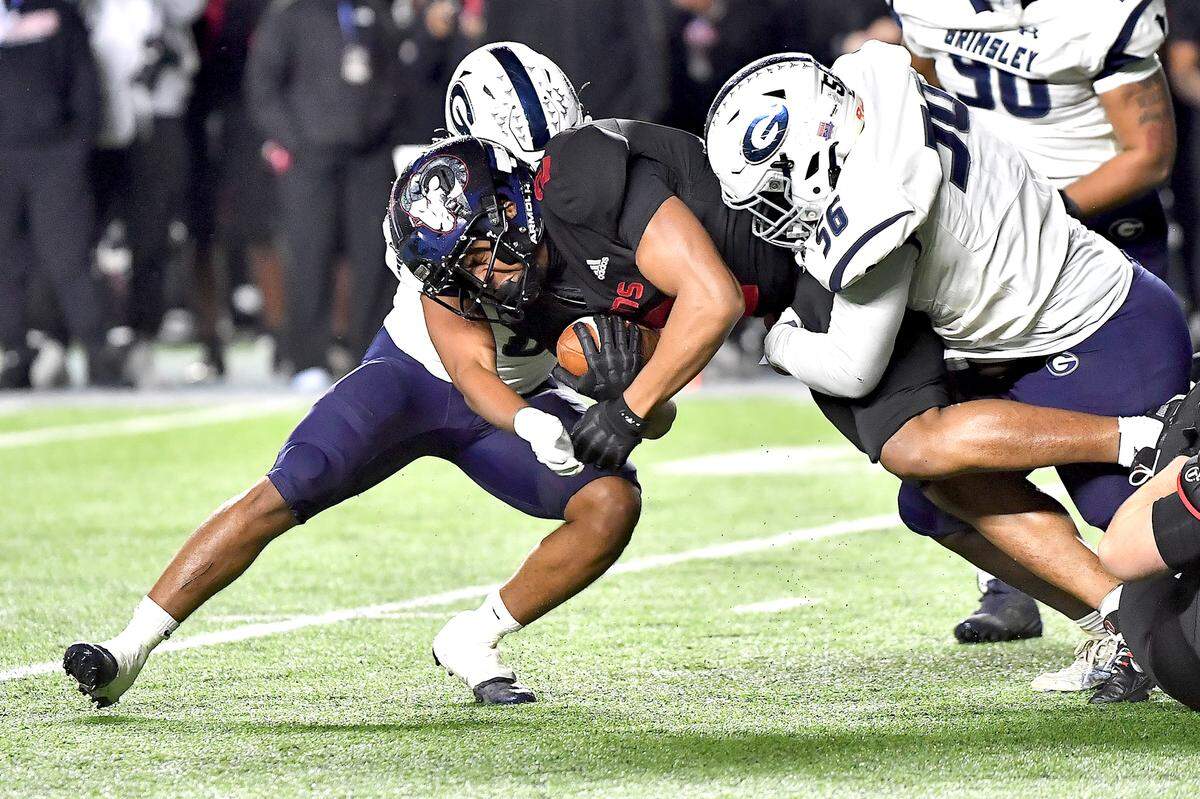 Grimsley’s Kyrie Millner (0) and Bakary Coulbary (56) tackle Rolesville’s Amir Brown (2) during the first half. The Rolesville Rams and the Greensboro Grimsley Whirlies met in the NCHSAA 4A football Championship Game in Chapel Hill, N.C. on December 20, 2024.
