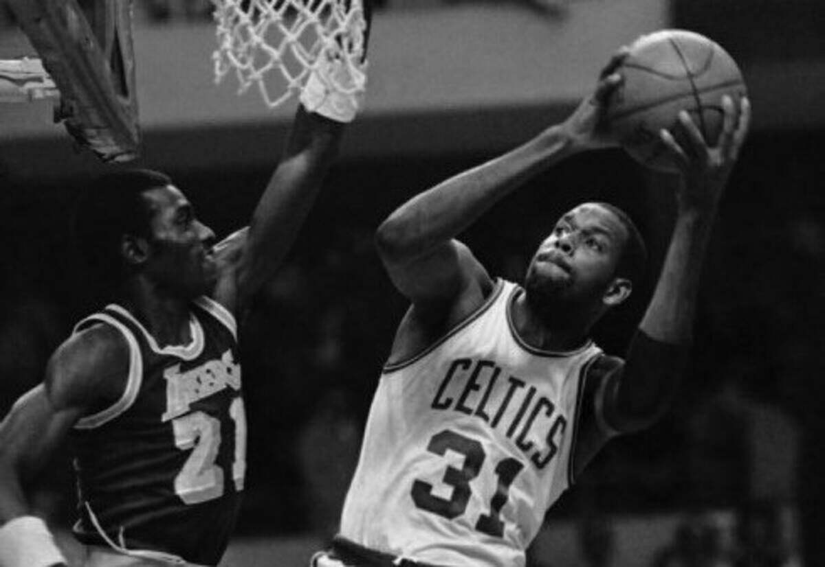 Cedric Maxwell of the Boston Celtics goes up for a shot at right as Los Angeles Lakers Michael Cooper defends with arm up in first quarter championship action at night on May 31, 1984 in Boston.