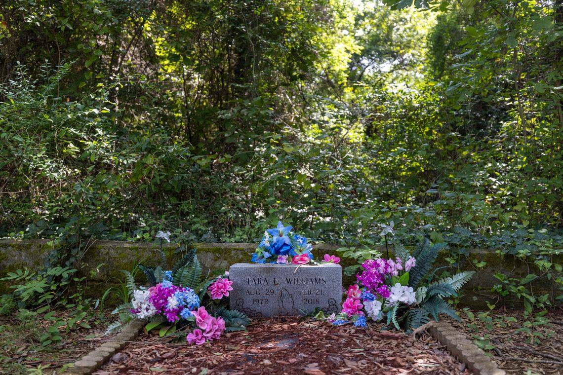 The grave of Tara L. Williams is surround by vegetation that shrouds part of the Wilkins Cemetery on Wednesday, August 24, 2022 in Dunn, N.C. Joy Williams began the effort to re-store the African-American cemetery 18 years ago.