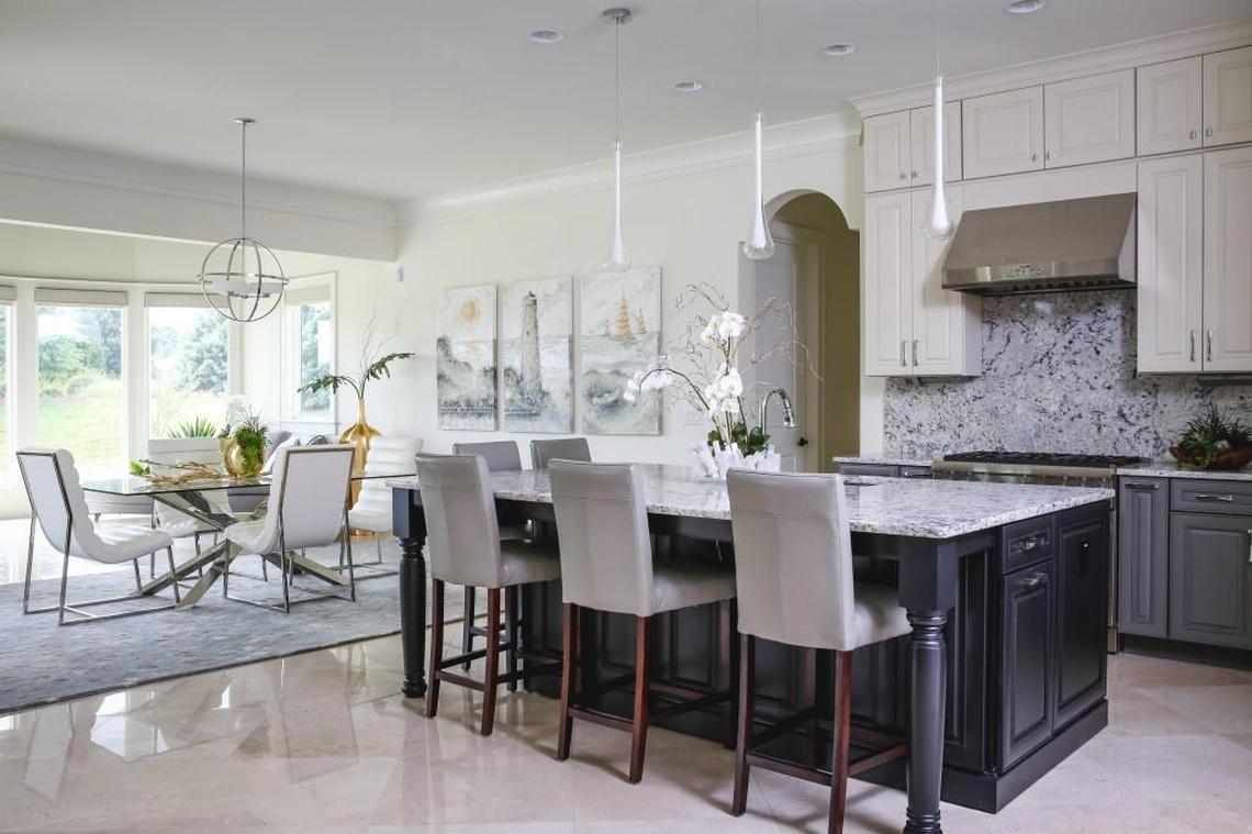 White-on-white trim and ceiling (Sherwin-Williams Alabaster) and walls (Sherwin-Williams Creamy). The kitchen countertop runs right up the wall. Notice the clean look of the backsplash with hidden outlets and switches. Commissioned artwork by local artist Dan Campbell.
